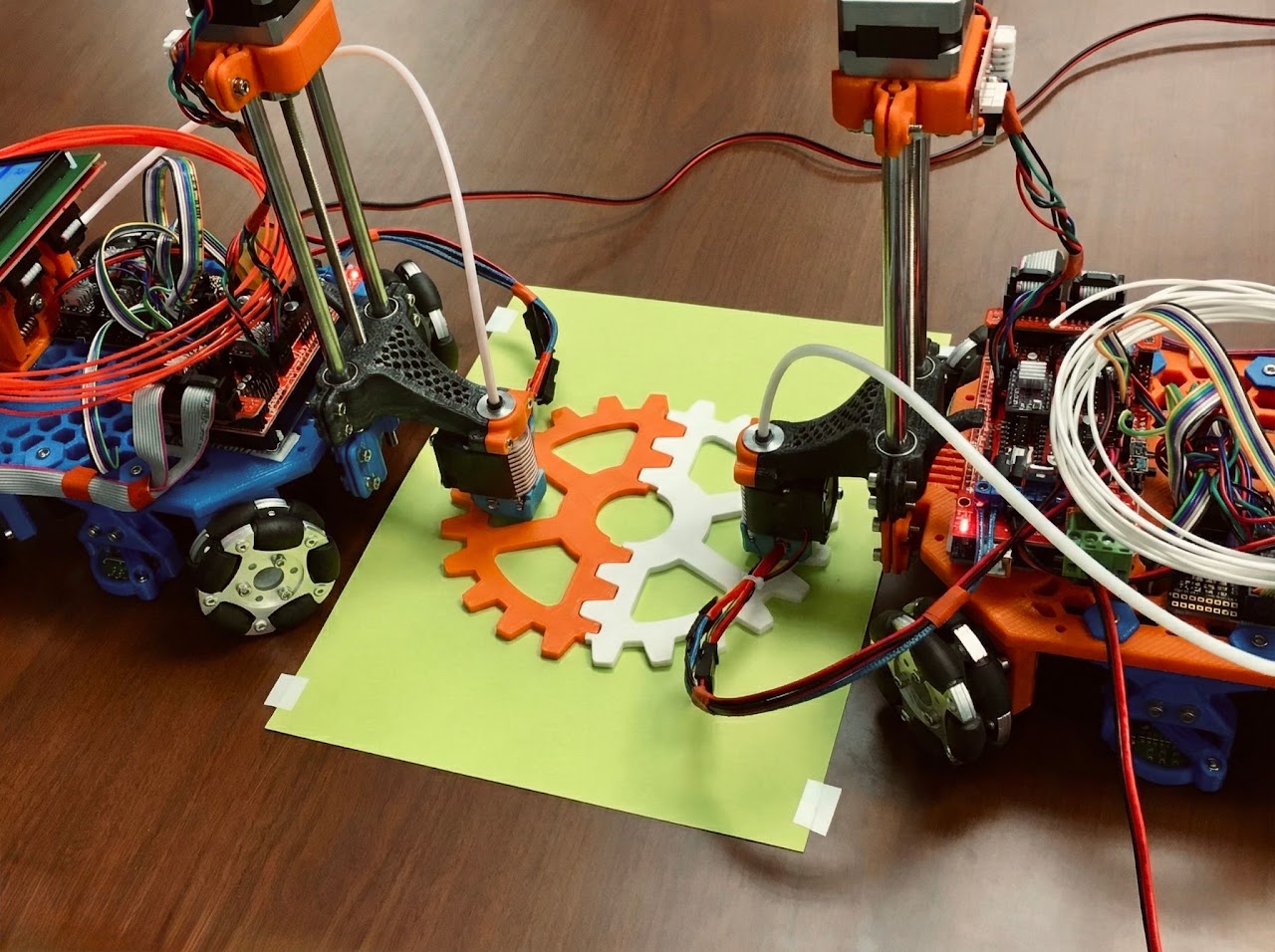 Two mobile 3D printers coordinating on a shared build surface